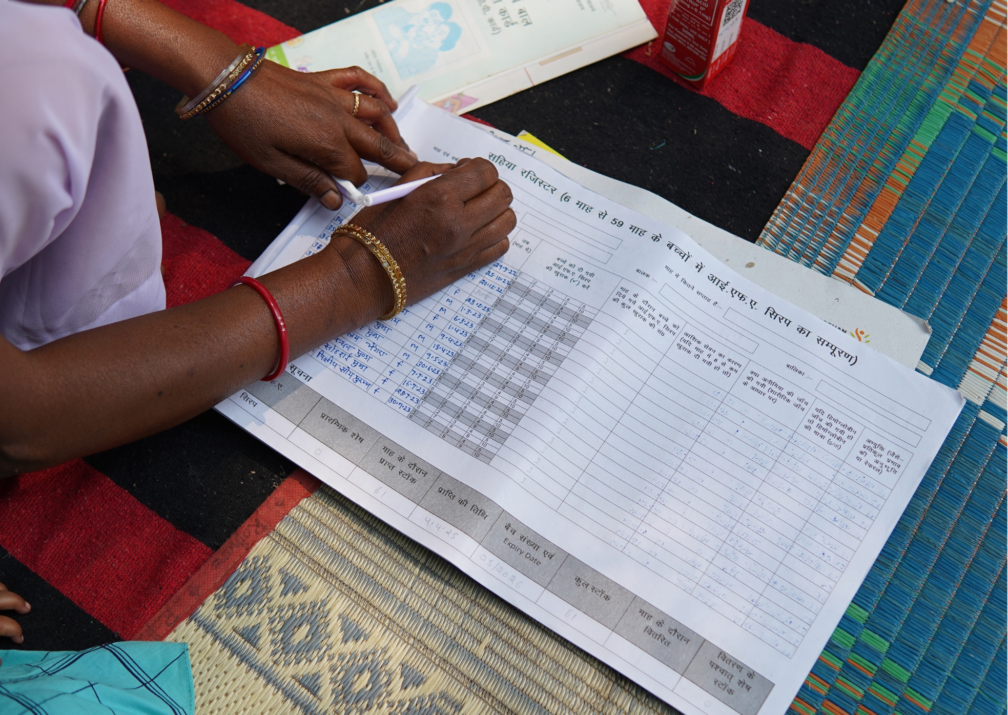 Sarita Devi recording data in her register, tracking children who have received IFA syrup